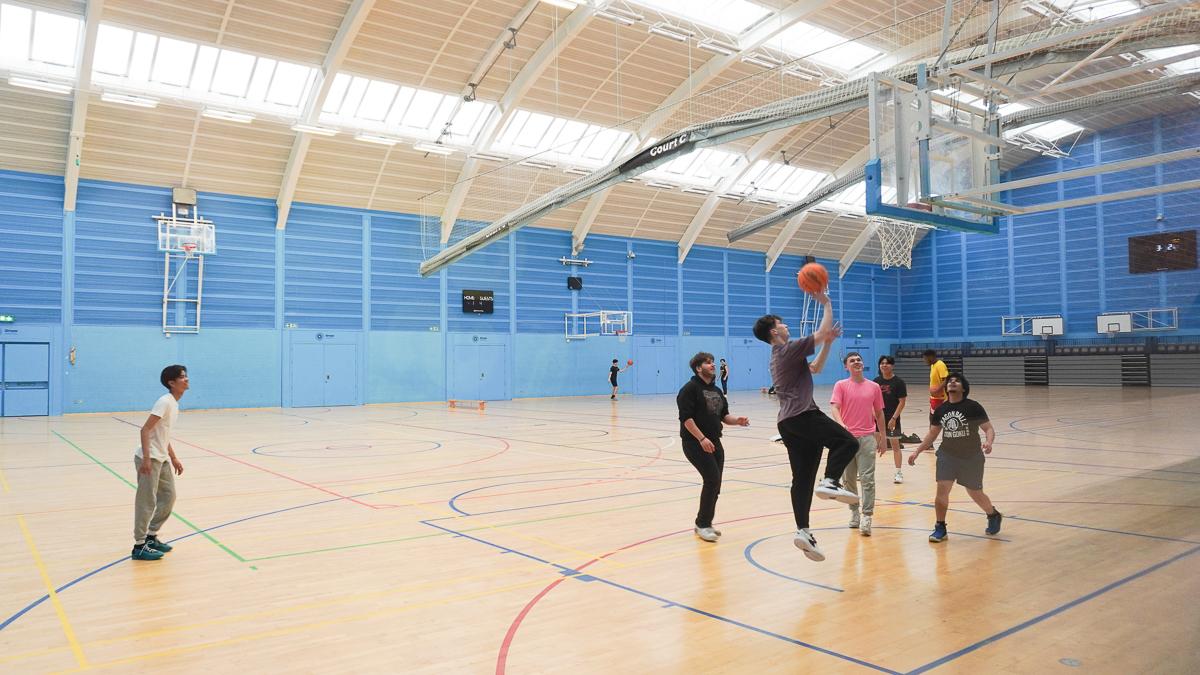 Youth playing basketball in a gym
